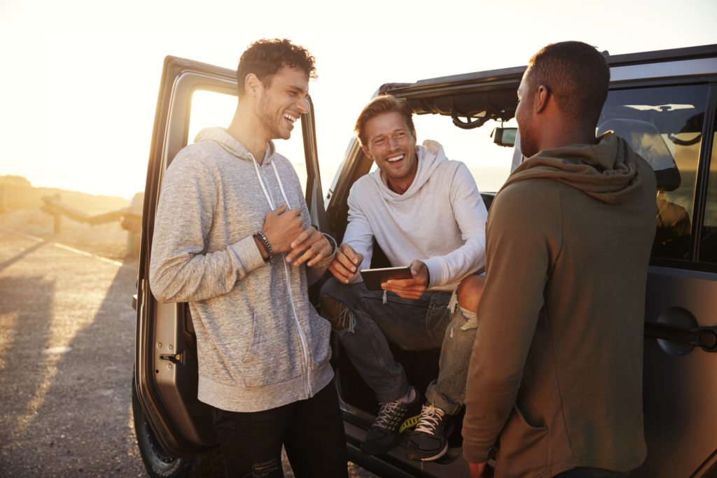 three-male-friends-on-a-road-trip-using-a-tablet-computer